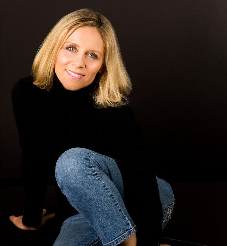 Jill Sylvester seated in a black sweater against a dark background